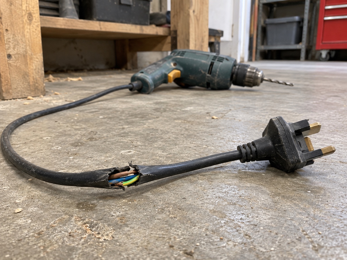 Illustrative generated photograph: damaged power-tool lead. Not a real incident photograph.